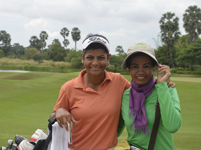 a golfer smilling with the caddie